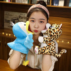 Person holding a blue shark plush toy and a leopard plush toy in front of a wooden background with books.