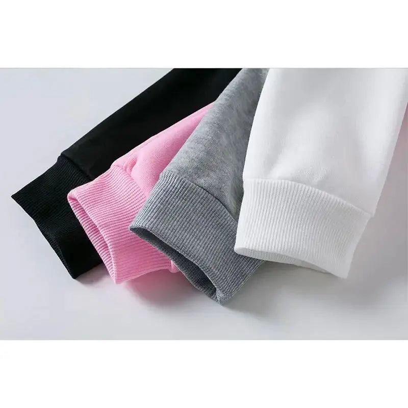 Four folded sweatpants in black, pink, gray, and white on a light gray background